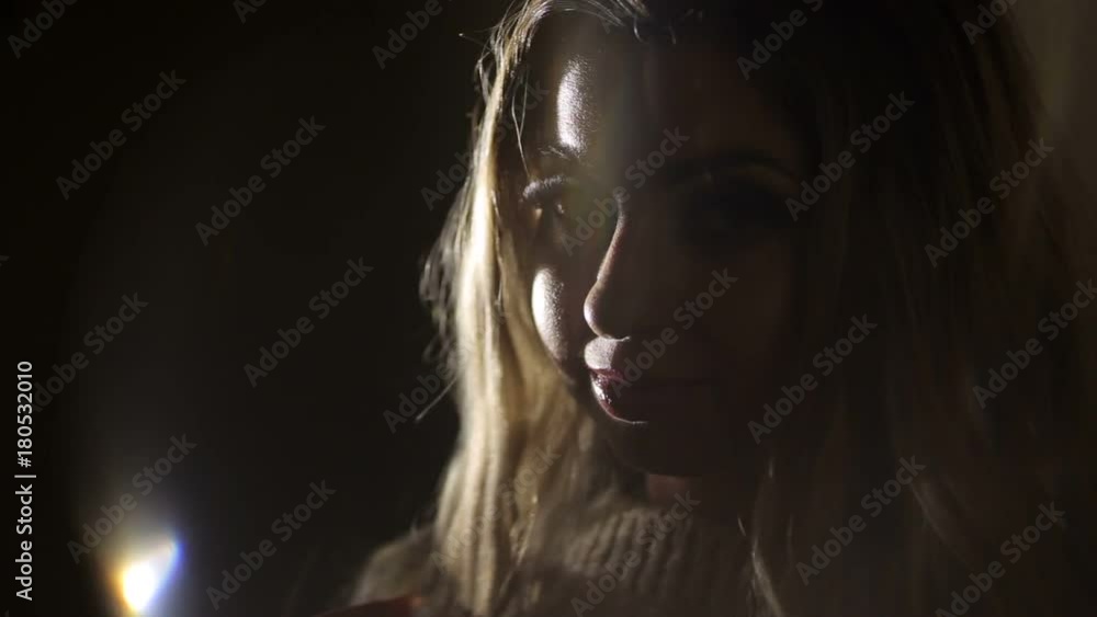 Close-up of silhouette of beautiful woman with long eyelashes and long curly hair, illuminated by artificial light. Close-up of silhouette of beautiful woman with long eyelashes and long curly hair, illuminated by artificial light.