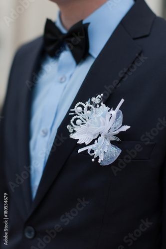 White boutonniere on wedding suit of groom