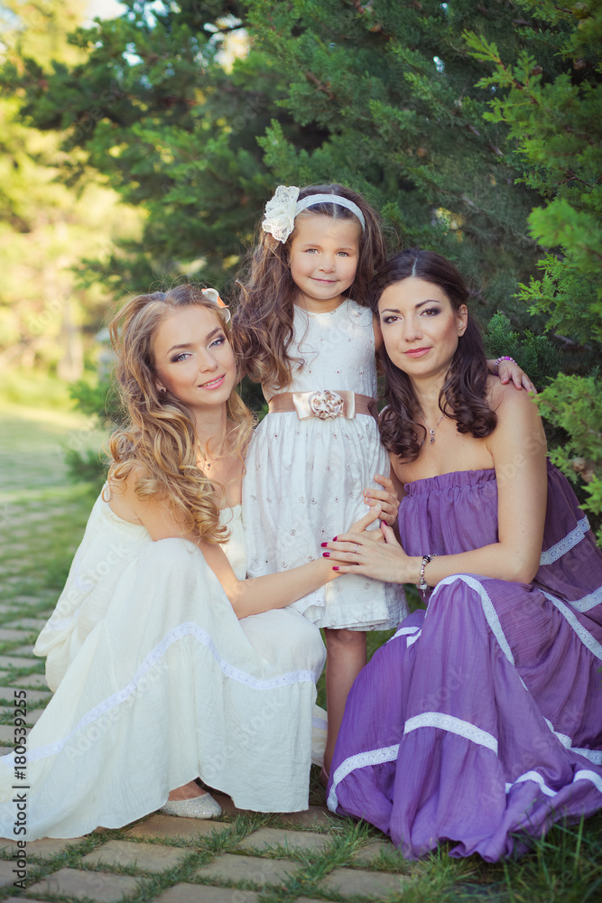 Stunning Brunette blond chestnut blue eyes sisters girls wearing stylish white purple dress enjoying life time together summer sunny day in garden forest on green grass happy smiling