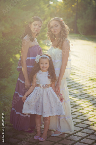 Amazing Brunette blond chestnut blue eyes sisters girls wearing stylish white purple dress enjoying vacation together spring sunny day in garden meadow on fresh grass lovely smiling
