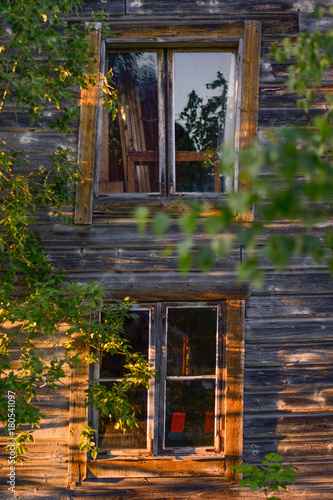 Windows on an abandoned building with the sun gracing the texture of the building.                 