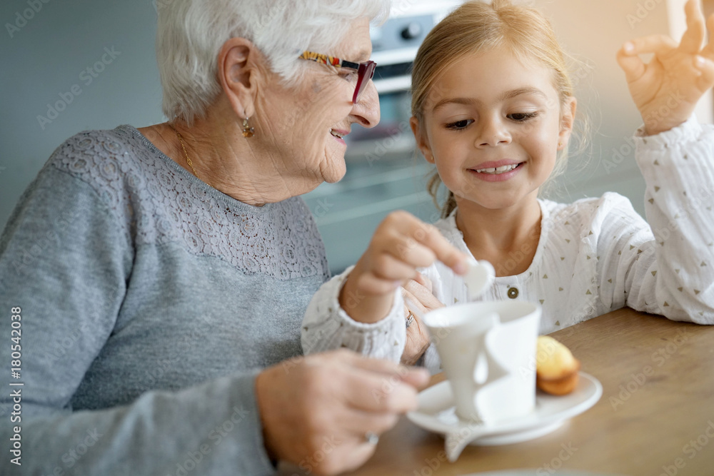 Little girl having tea time with grandma Little girl having tea time with grandma