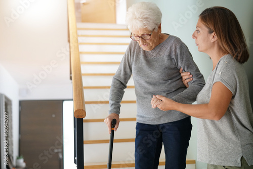 Bild auf Leinwand Homecare helping elderly woman going down the stairs