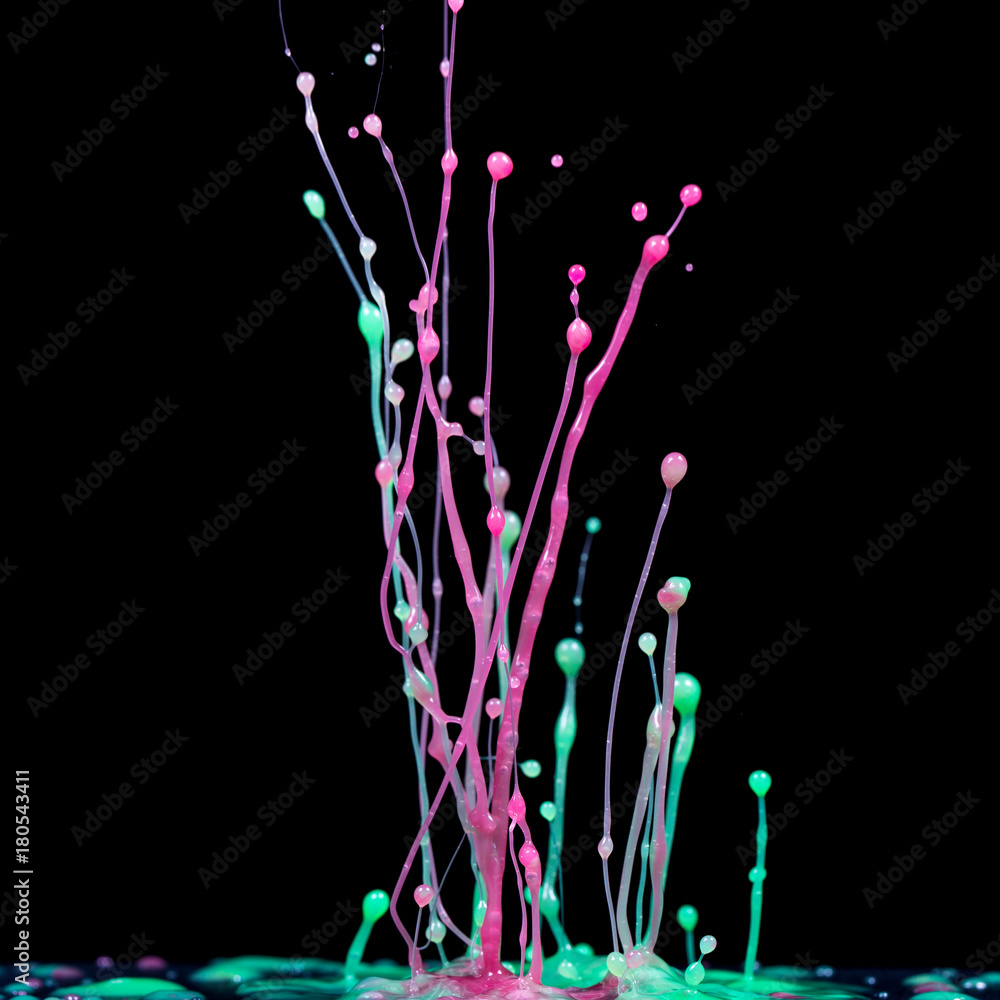 explosion of splashes and bursts of colour fluid paint or ink on a black background