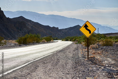 Curved road with sign in Death Valley, California, USA