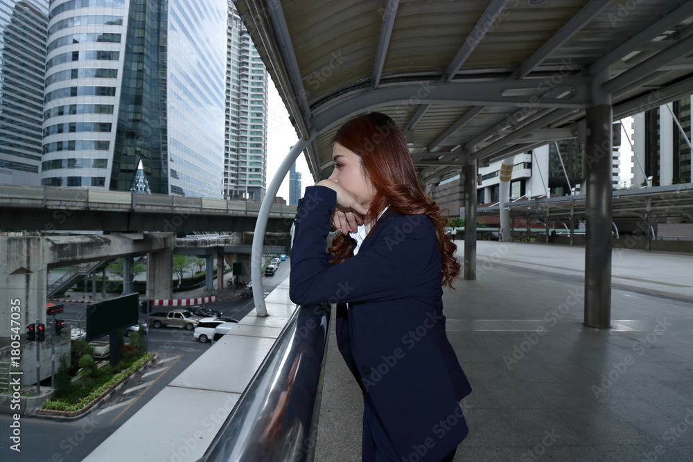 Wide angle shot of stressed frustrated young Asian business woman  feeling tired or disappointment at urban city background.