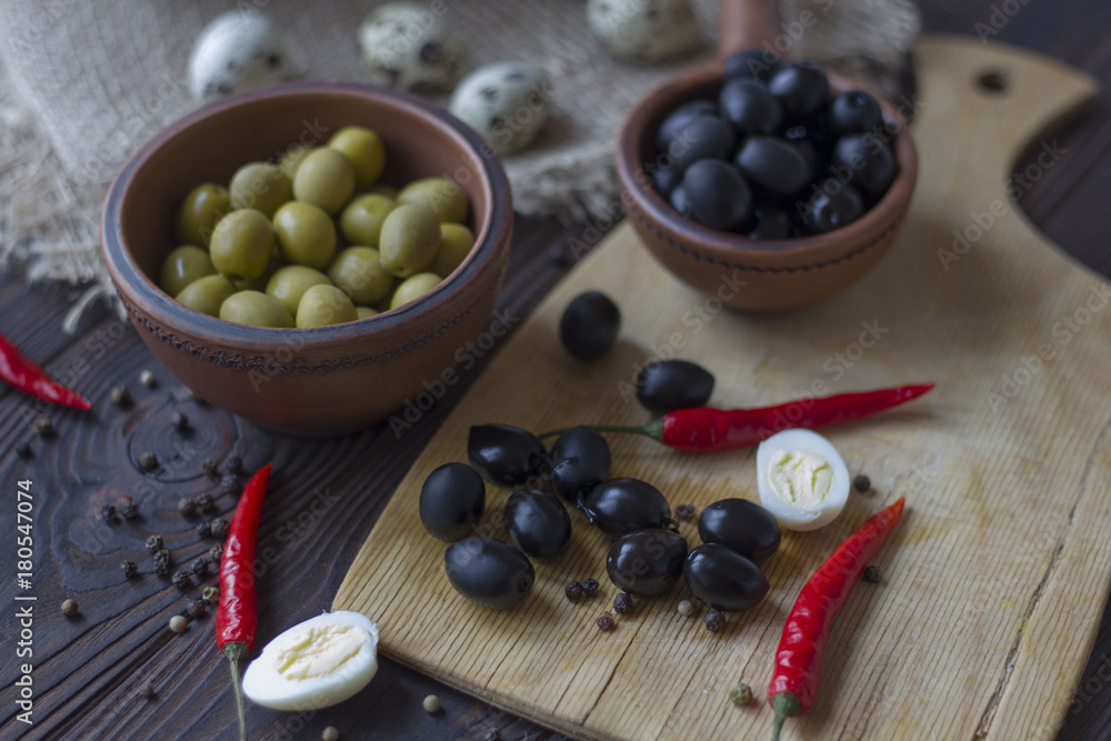 quail eggs, olives, chili and spices on a wooden table quail eggs, olives, chili and spices on a wooden table