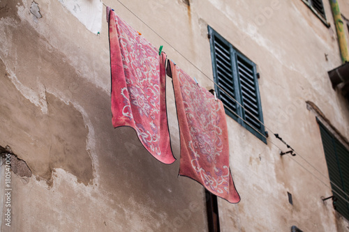 Fotografie panni stesi fuori di un palazzo accanto ad una finestra con persiane chiuse