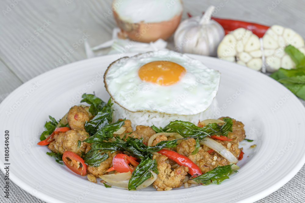 Crispy chicken cooked with sweet basil eat with rice and egg.it is a very delicious Thai food. Crispy chicken cooked with sweet basil eat with rice and egg.it is a very delicious Thai food.