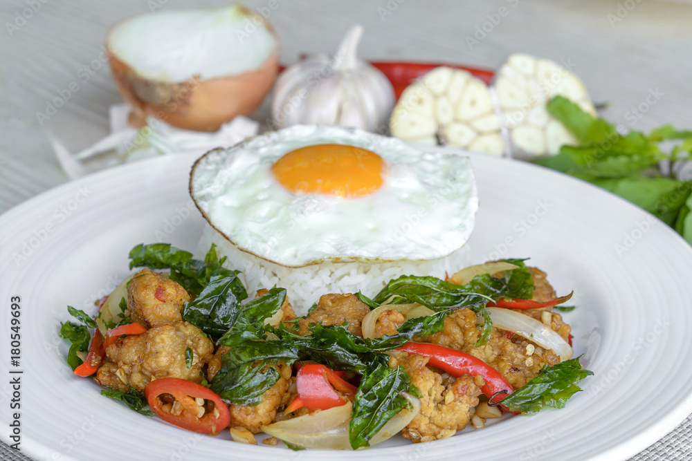 Crispy chicken cooked with sweet basil eat with rice and egg.it is a very delicious Thai food. Crispy chicken cooked with sweet basil eat with rice and egg.it is a very delicious Thai food.