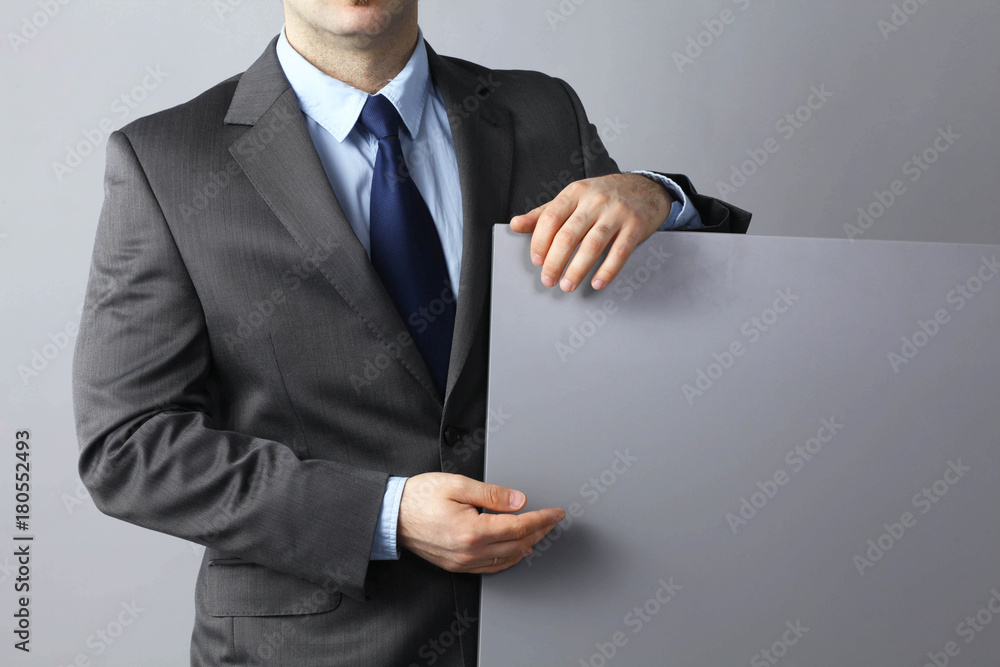 Businessman standing and holding a blank board Businessman standing and holding a blank board