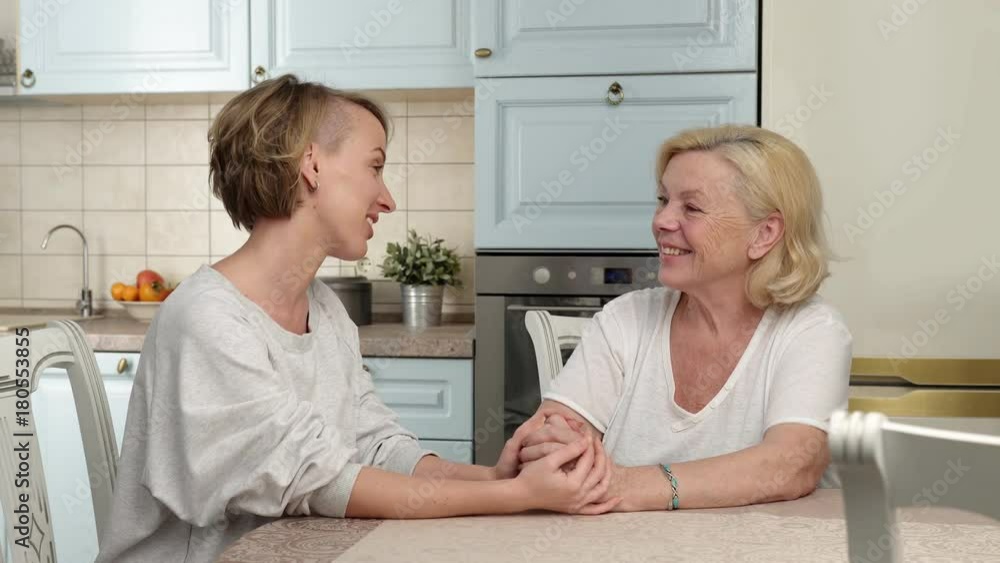 Happy mature mother talking with her adult daughter Happy mature mother talking with her adult daughter