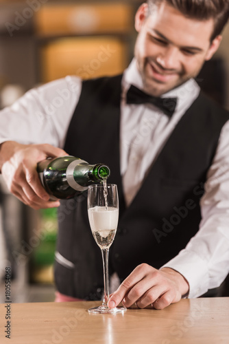 bartender pouring champagne into glass