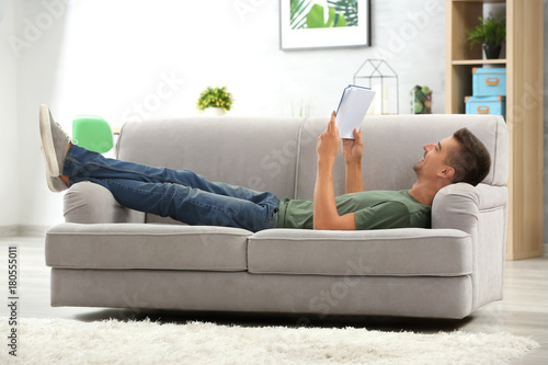 Young man reading book on s...