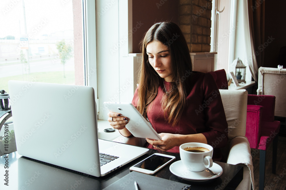 Young attractive woman sitting in a cafe in the morning before her work and planning tasks for the whole day. Beautiful lady talking on the phone and discussing business strategies with her colleague. Young attractive woman sitting in a cafe in the morning before her work and planning tasks for the whole day. Beautiful lady talking on the phone and discussing business strategies with her colleague.