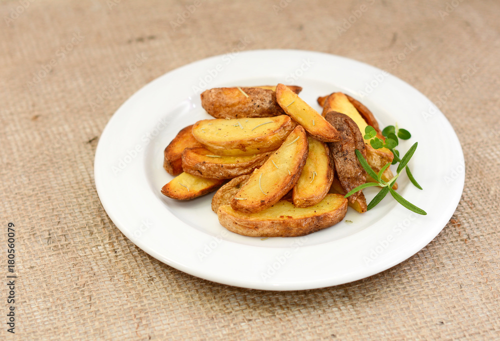 Fried potato wedges with herbs on plate. Fried potato wedges with herbs on plate.