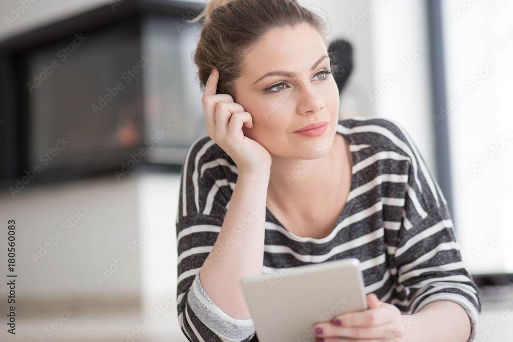 woman using tablet computer in front of fireplace woman using tablet computer in front of fireplace