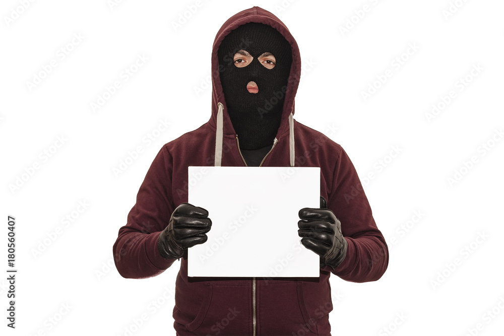 Police lineup or mugshot concept with a burglar or thief wearing a ski mask or balaclava and holding a blank white cardboard with copy space isolated on white background with clipping path Police lineup or mugshot concept with a burglar or thief wearing a ski mask or balaclava and holding a blank white cardboard with copy space isolated on white background with clipping path