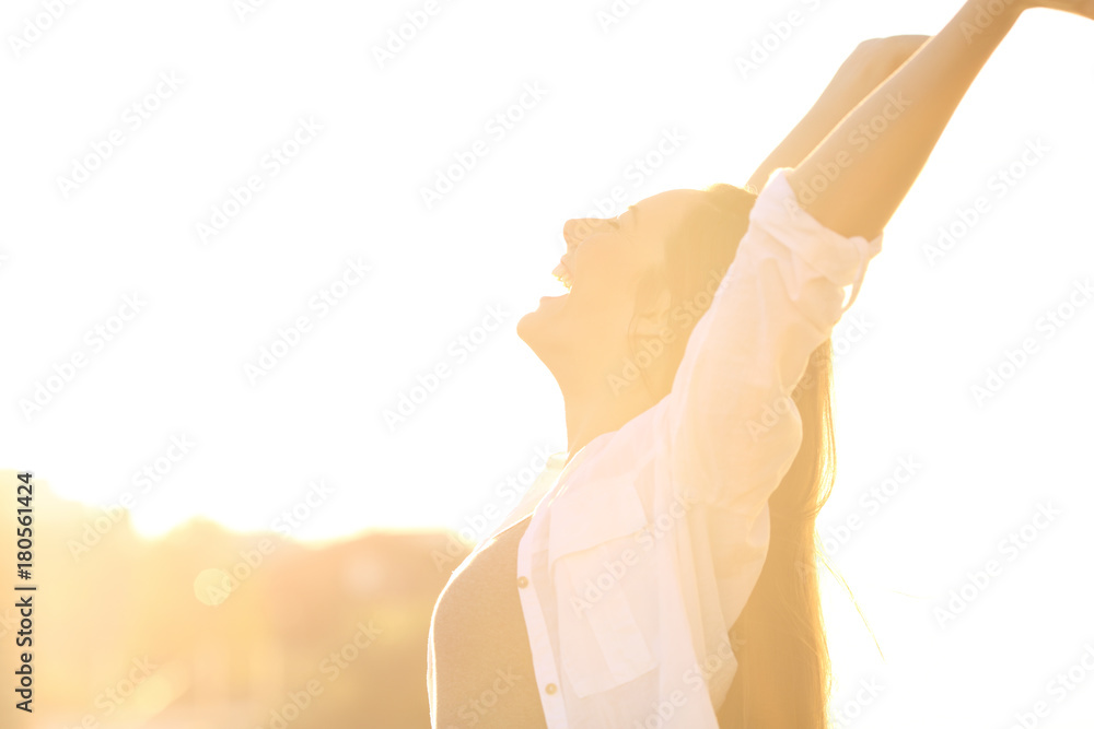 Excited woman raising arms at sunset - obrazy, fototapety, plakaty 