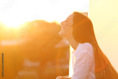 Woman breathing at sunset in a balcony photo