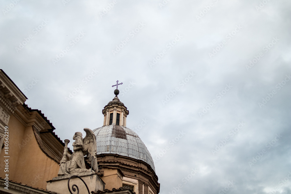 dome with angel on a baroque church in rome with a cloudy sky background