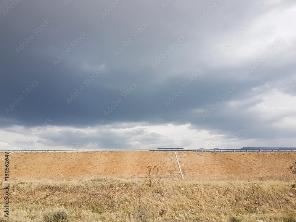 cloudy sky view with a highway at background