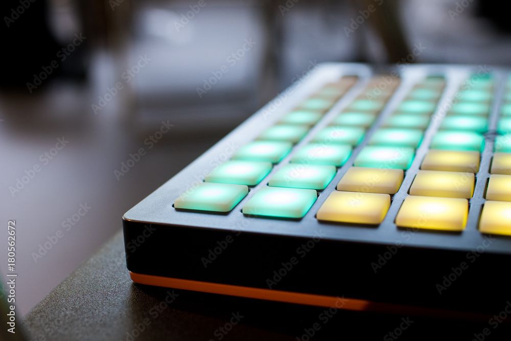musical instrument for electronic music with a matrix of 64 keys in 8 x 8 files..Pad for music with buttons on angles illuminated by yellow and green musical instrument for electronic music with a matrix of 64 keys in 8 x 8 files..Pad for music with buttons on angles illuminated by yellow and green