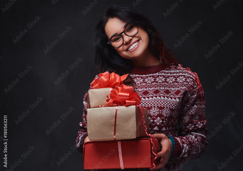 A woman in eyeglasses holds Christmas gifts. A woman in eyeglasses holds Christmas gifts.