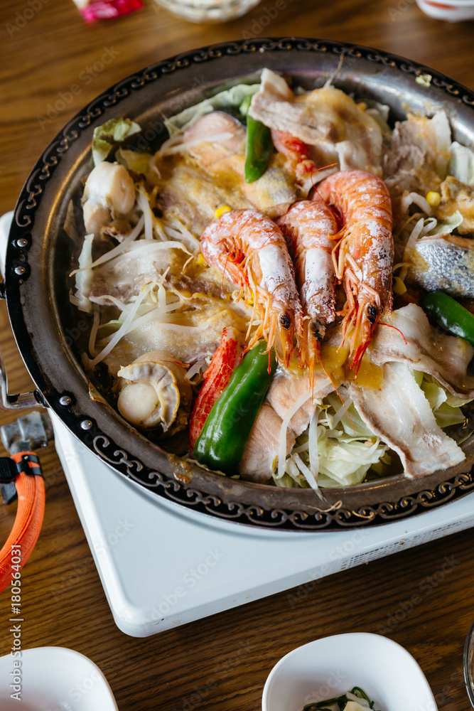 Nabe (Japanese hot pot dishes ) including prawns, salmon, pork, vegetables and mushrooms at the restaurant in Hokkaido, Japan. Nabe (Japanese hot pot dishes ) including prawns, salmon, pork, vegetables and mushrooms at the restaurant in Hokkaido, Japan.