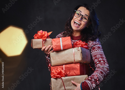 A woman holds Christmas gifts.