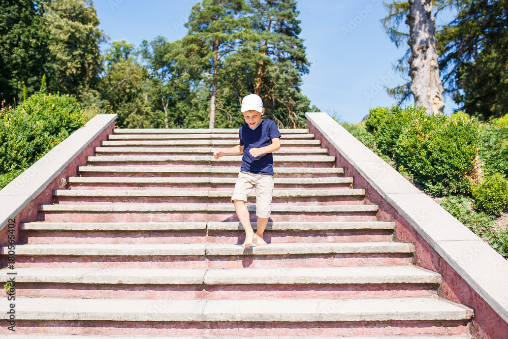 Boy rushing down on stairs barefoot. Concept childhood image with copy space