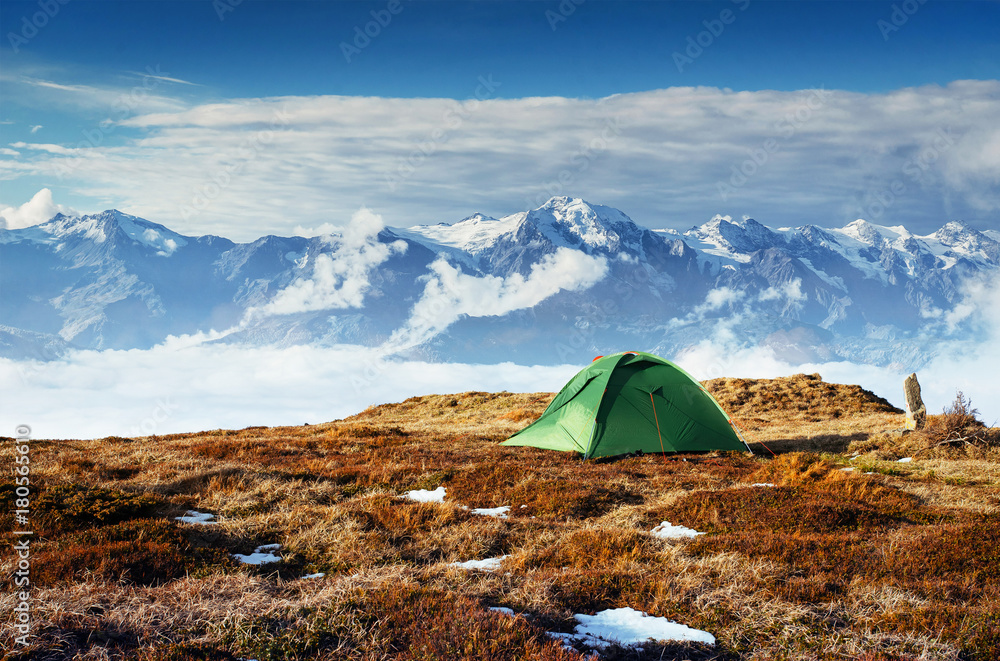 Tent against the backdrop of snow-capped mountain peaks. The view from the mountains to Mount Ushba Mheyer, Georgia. Europe