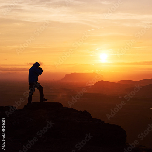 Nature photographer with digital camera on top of the mountain.