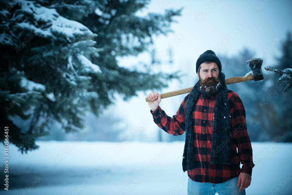 Christmas hipster lumberjack with ax in wood. StockFoto Adobe Stock