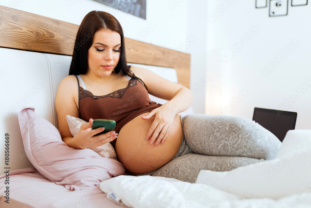 Beautiful pregnant woman using phone