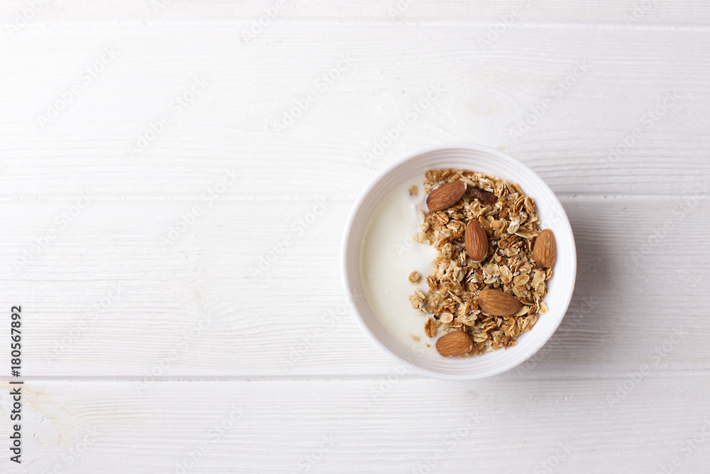 Bowl of whole grain muesli with yogurt on white background, top view Bowl of whole grain muesli with yogurt on white background, top view