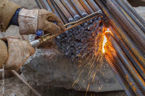 Gas cutting of metal fittings. Working gloves. Sparks.