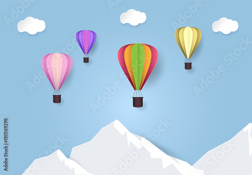 Paper art of hot air balloon travel in blue sky over mountain. Paper cut style illustration.