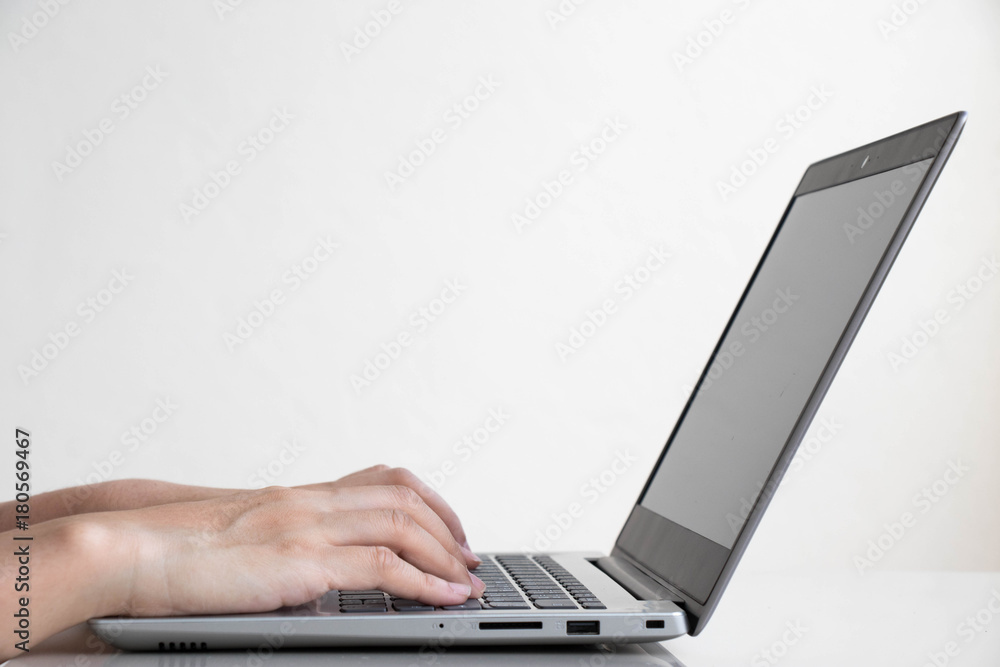 Business man use the computer notebook for working with white wall background Business man use the computer notebook for working with white wall background