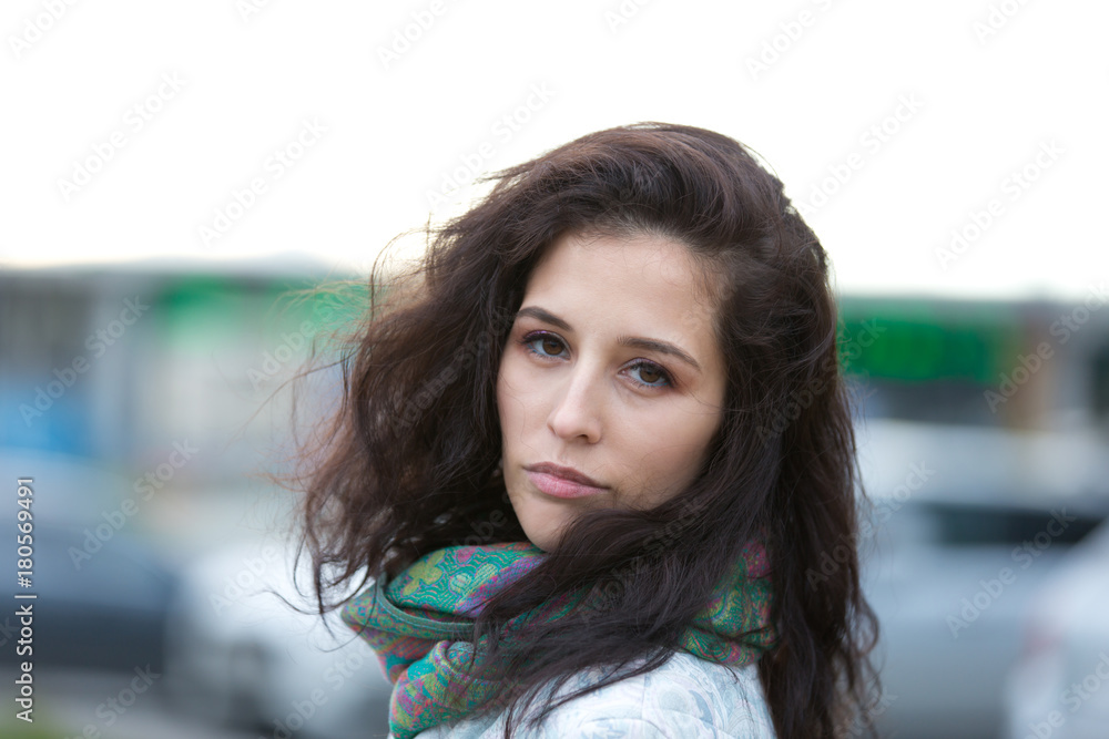 Obraz premium Portrait of a beautiful girl in an urban landscape in autumn