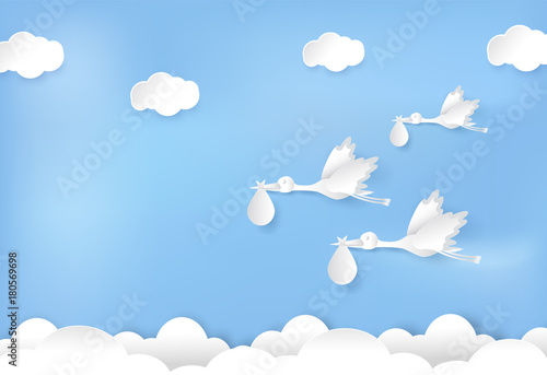 Paper art of stork flying with baby on blue sky paper cut style illustration