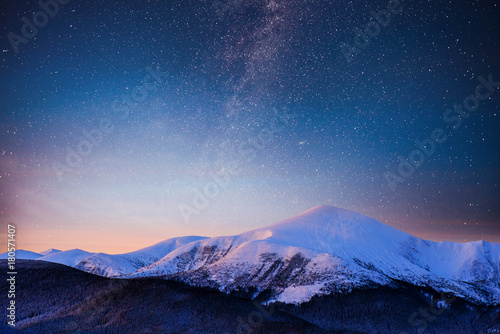 Beautiful winter landscape in the Carpathian mountains. Vibrant night sky with stars and nebula and galaxy. Deep sky astrophoto © standret
