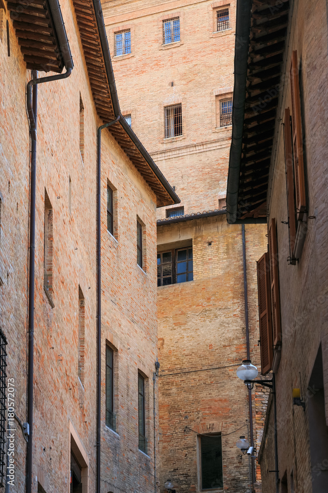 Urbino, Italy - August 9, 2017: architectural elements of a building in the old town of Urbino. Red brick and windows with shutters
