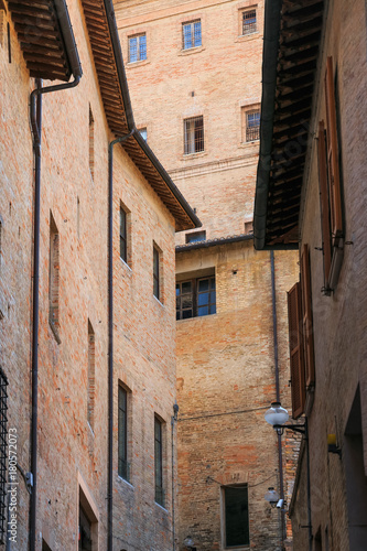 Urbino, Italy - August 9, 2017: architectural elements of a building in the old town of Urbino. Red brick and windows with shutters © makam1969