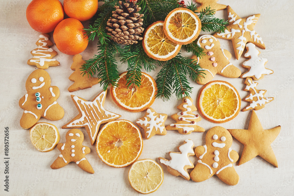 Christmas gingerbread cookies and dried orange and spices on white table. Chairs Christmas trees, cones and Christmas decorations Christmas gingerbread cookies and dried orange and spices on white table. Chairs Christmas trees, cones and Christmas decorations