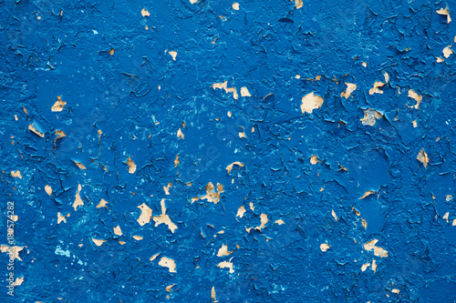 Blue cracked paint on a concrete wall. Old painted blue wall texture, grunge background, cracked paint.