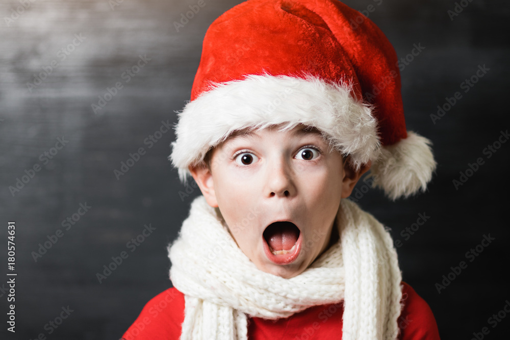 Small boy in red shirt and white knitted scarf holding a white sheet of paper with text Small boy in red shirt and white knitted scarf holding a white sheet of paper with text