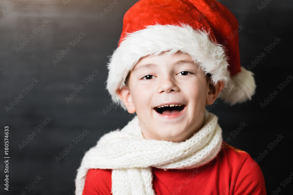 Small boy in red shirt and white knitted scarf holding a white sheet of paper with text Small boy in red shirt and white knitted scarf holding a white sheet of paper with text