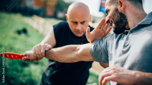 Foto Self defense disarming technique against threat and knife attack