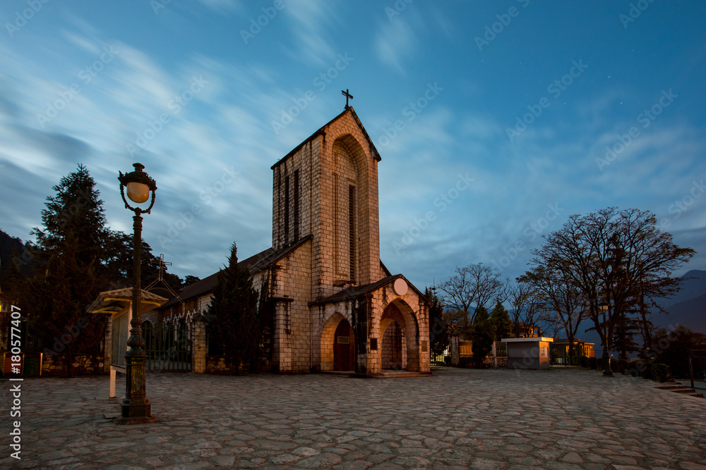 Obraz premium ancient stone church of sapa with blue night sky most popular traveling destination in sapa norhtern of vietnam